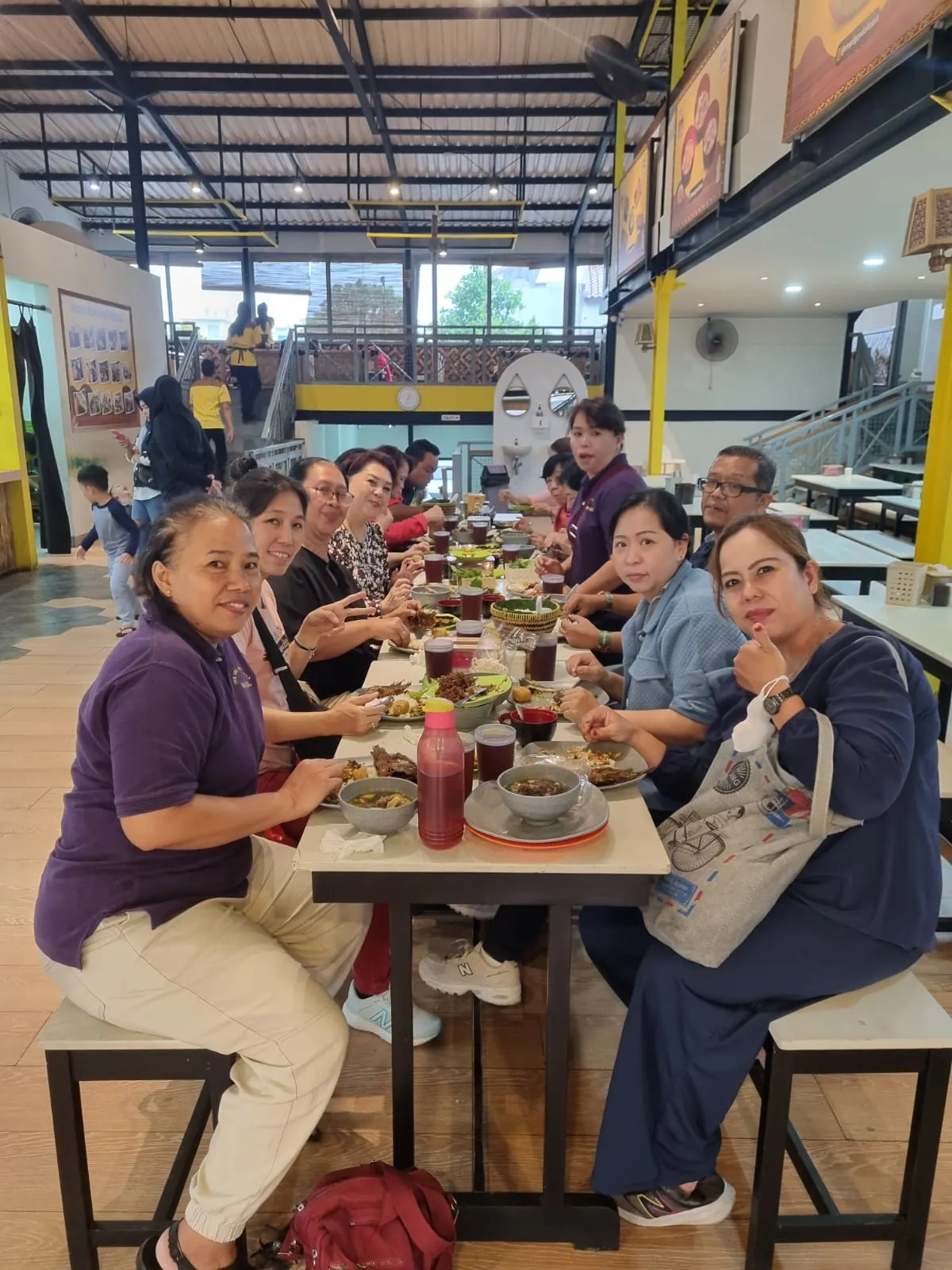 Rombongan sekitar sepuluh orang makan bersama di meja panjang Sibabah Kota